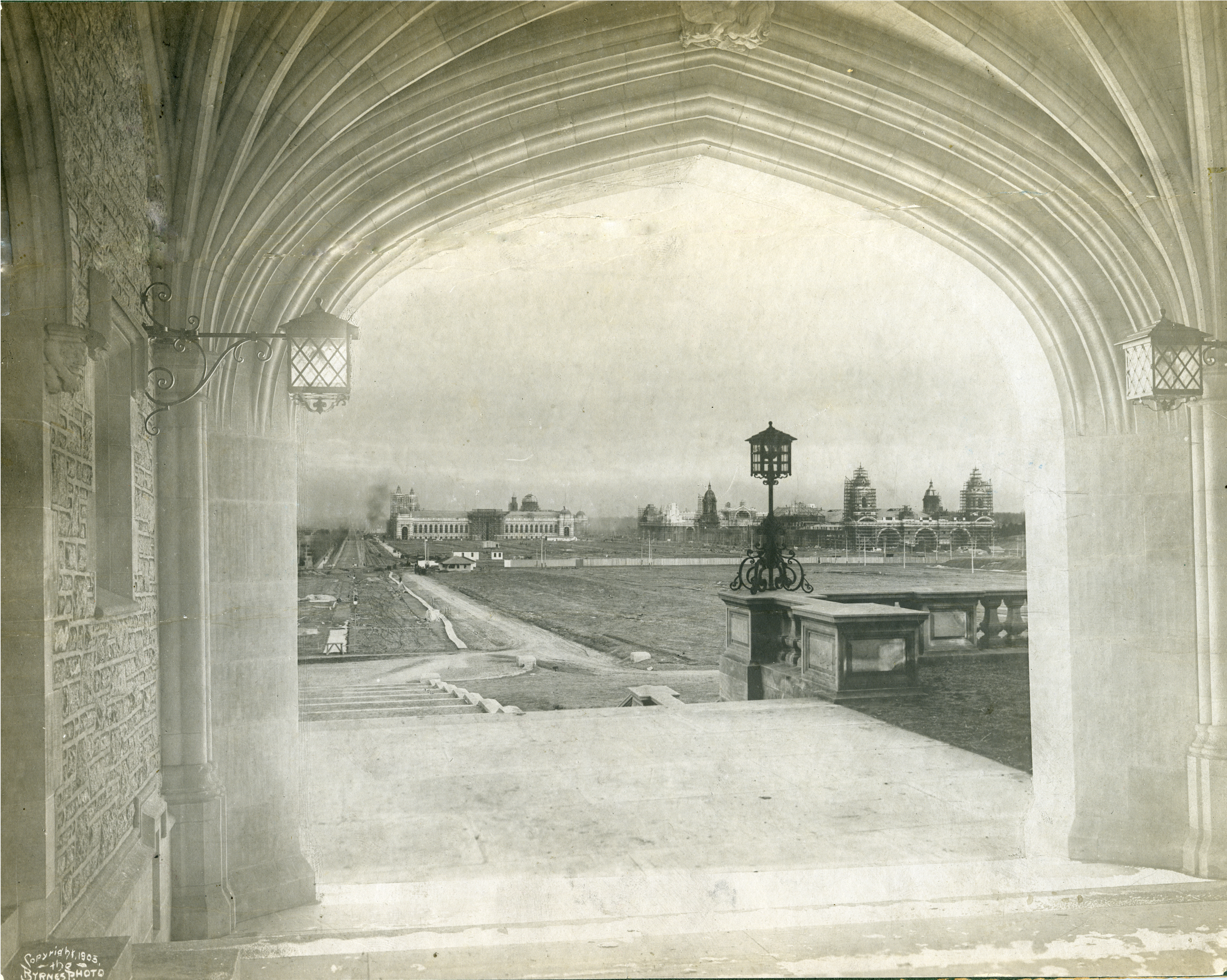 Black and white photo of landscape viewed through archway of building